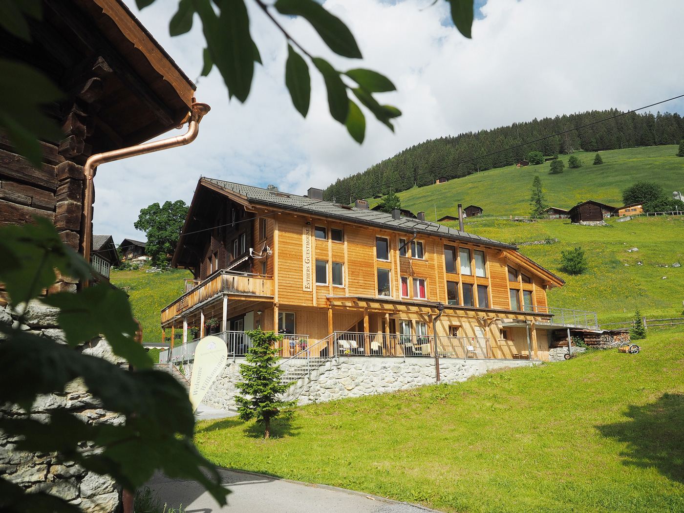 Esther's Guesthouse, a wooden chalet in Gimmelwald with the Bernese Alps behind it